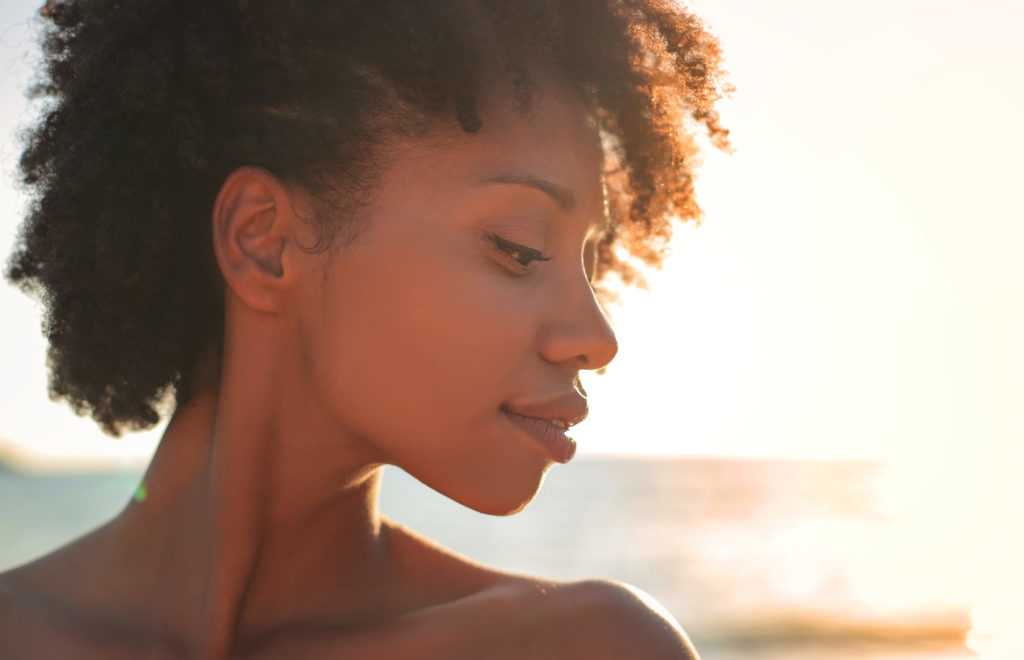 A fresh faced african american woman blissfully happy on a beach