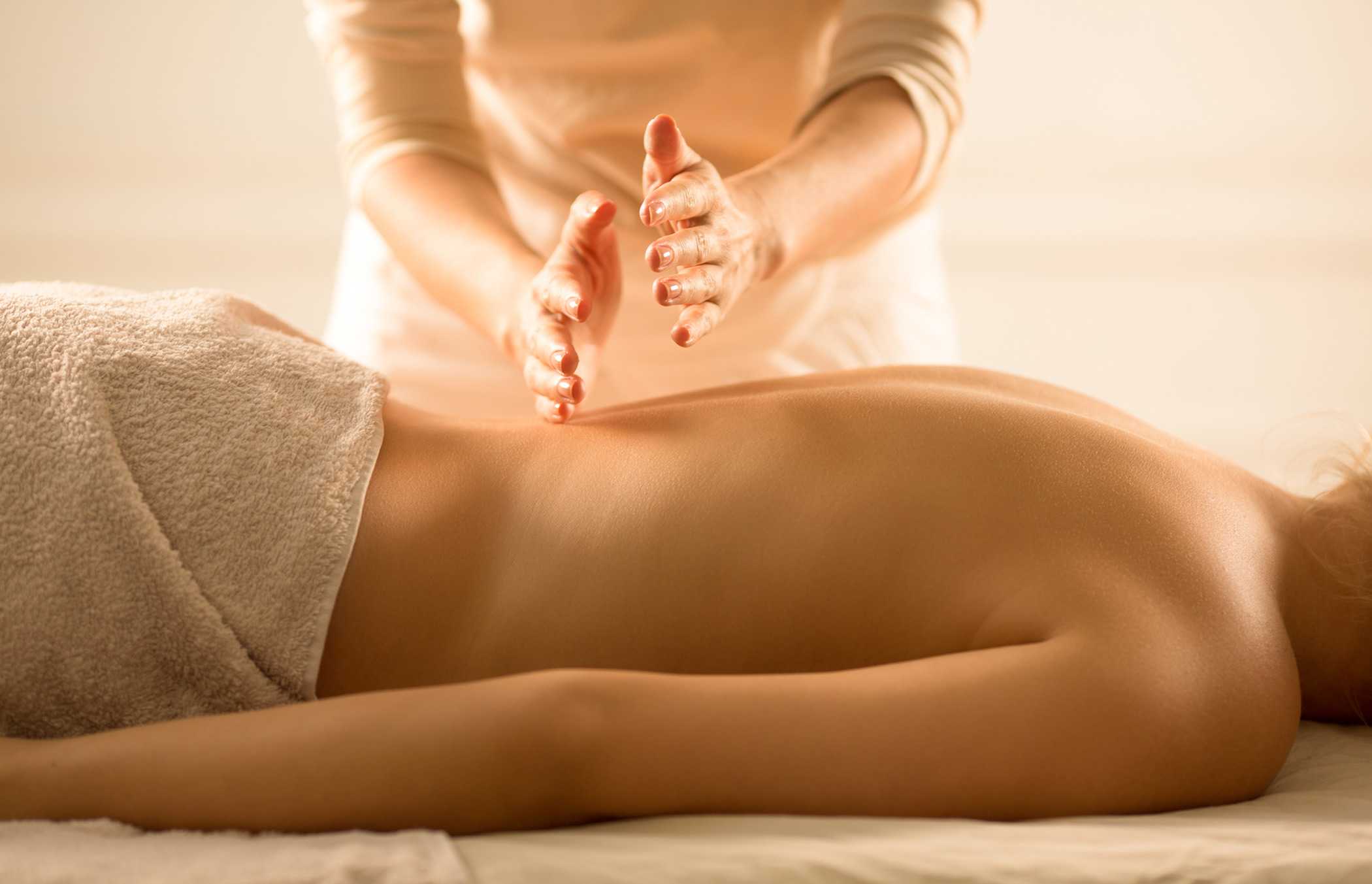 A woman getting a back massage in a warmly lit room