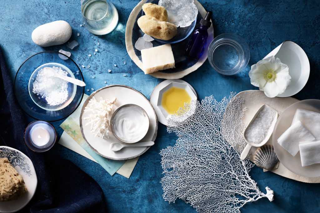 an array of light snacks on top of a table with fresh flowers and spreads